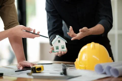 Engineers consulting team close up to design building blueprints paper for Stock Photos