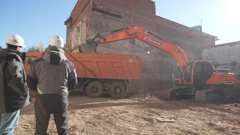Engineers control excavator loading soil into truck at site Stock Footage 314648665
