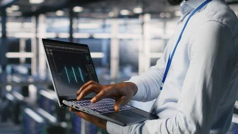 Engineers in data center reviewing large language model visualizations on laptop Foto stock