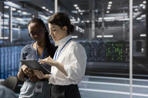 Engineers in data center using device, verifying firewall configurations 스톡 사진