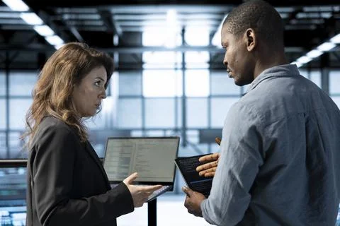 Engineers in data center using devices, employing machine learning models Stock Photos