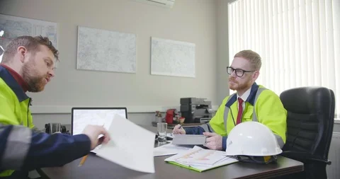 Engineers deal with paperwork in office Stock Footage 107383766
