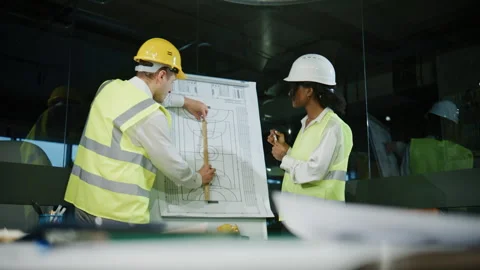 Engineers discuss blueprint in office while reviewing sports facility design 스톡 동영상 323048514