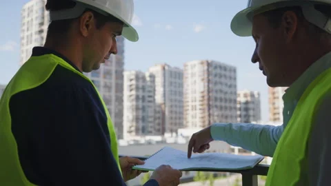 Engineers discussing blueprint on construction site Stock Footage 160601568