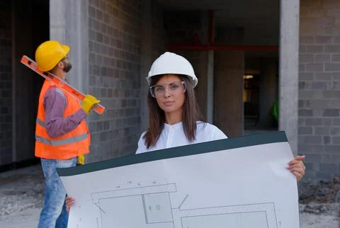 Engineers discussing blueprint on construction site Stock Photos
