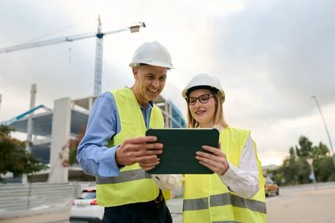 Engineers discussing construction plans using digital tablet Stock Photos