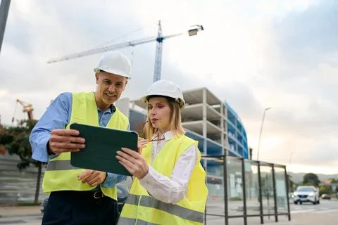 Engineers discussing construction project plans using tablet Stock Photos