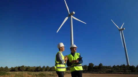 Engineers discussing maintenance of wind turbines in field Video stock 303553964