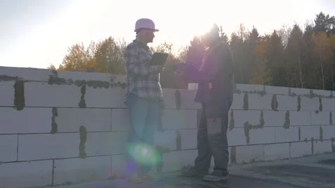 Engineers discussing plans on construction site at sunset Stock Footage 316885569