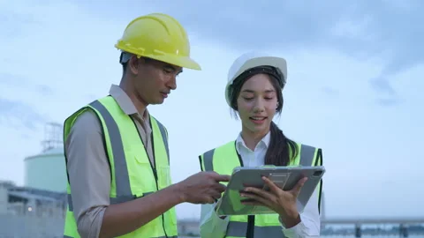 Engineers discussing plans on-site with a tablet Video stock 297778165