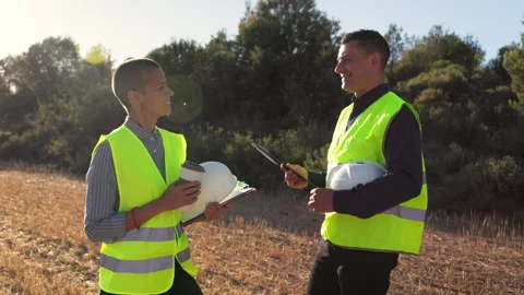 Engineers discussing project plans at construction site outdoors Video stock 305663645