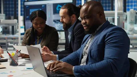 Engineers in factory office using laptop to collect data, increasing energy Stock Photos