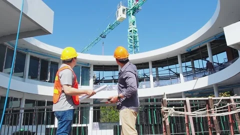 Engineers in front of mechanical crane working on the construction site. Stock Footage 274953843