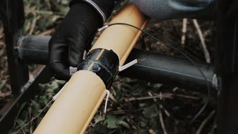 An engineers gloved hands inspecting a plastic gas pipe connection for defects. Stock Footage 318267929
