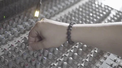 An engineers hand adjusting a potentiometer on a sound mixer, camera truck right Stock Footage 89835517