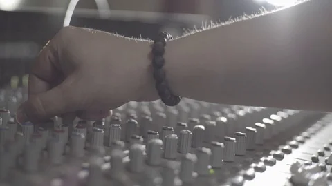 An engineers hand adjusting a potentiometer on a sound mixer, camera truck left Stock Footage 89835523