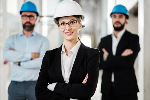 Engineers in hardhats posing in new building Fotos de archivo