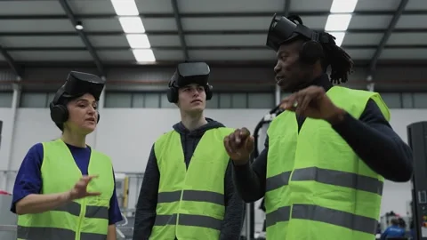 Engineers having experience with virtual reality glasses in robotic factory Stock Footage 197469863