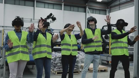 Engineers having experience with virtual reality glasses in robotic factory Stock Footage 198370005