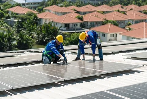 Engineers in helmets installing solar panel Stock Photos