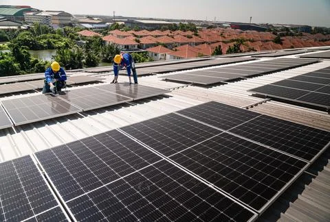 Engineers in helmets installing solar panel Stock Photos