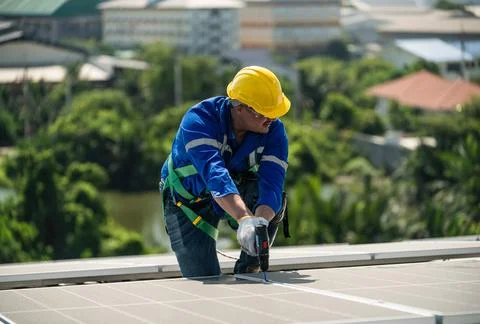 Engineers in helmets installing solar panel Stock Photos