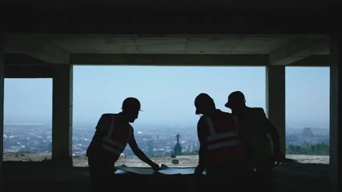 Engineers with helmets opening the blueprint of building project and discussing Vídeos de archivo 148356475