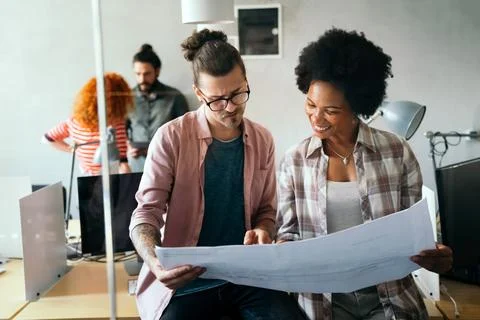 Engineers helping design work on blueprints, collaborate on structural anal.. Stock Photos