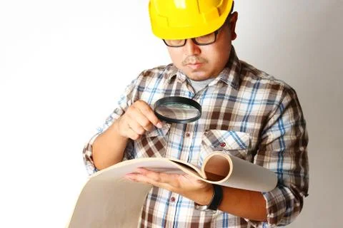 Engineers hold construction paper using a magnifying glass Stock Photos
