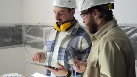 Engineers hold documents and a tablet and discuss construction details Stock Footage 235541256