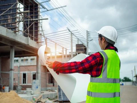 Engineers holding blueprint project working outdoors building side with blu.. Stock Photos