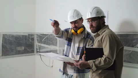 Engineers inspect the building on the construction site and discuss the drawings Stock Footage 236557256