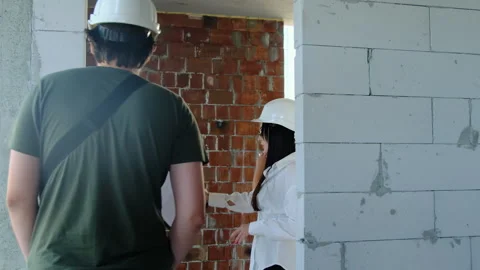 Engineers inspect spacious room during shift on construction site Stock Footage 317609212