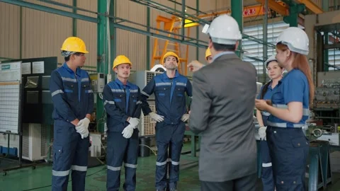 Engineers listen intently to a manager in an industrial plant Stock Footage 341925091