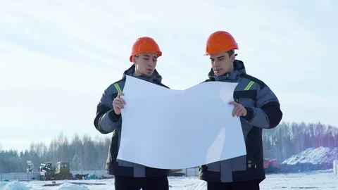 Engineers look at construction drawing on cold winter day Stock Footage 103090524