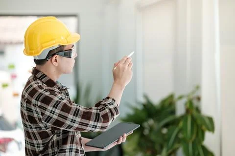 Engineers man standing in front of windows. Engineer man point his hand to Stock Photos