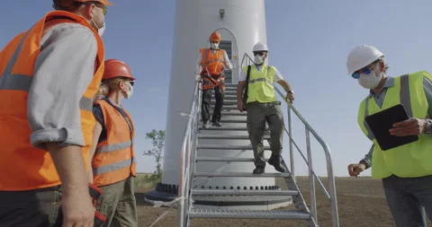 Engineers in masks walking away windmill Stock Footage 140291142