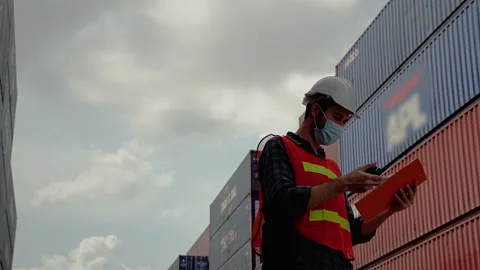 Engineers must wear a mask while using the radio to communicate in the warehouse Stock-Footage 130880104