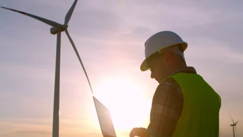 Engineers Operate Clean Energy Technology Using Laptops Next To Wind Turbines Stock Footage 314344986