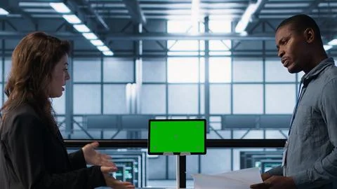 Engineers overseeing server room with mockup device, reading documentation Stock Photos
