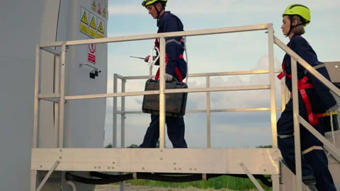 Engineers in safety gear working at height walking to the maintenance station Stock Footage 166313188