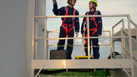 Engineers in safety gear working at height standing at the maintenance station Stock Footage 166315014