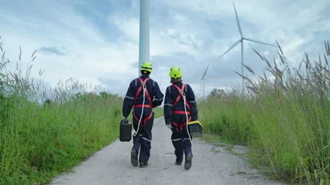 Engineers in safety gear working at height walking to the wind turbine Stock Footage 167643331