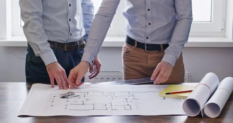 Engineers shake hands and start to discuss flat drawings Stockbeeldmateriaal 243726645