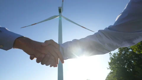 Engineers shaking hands after concluding deal of construction of wind mill farm  Stockbeeldmateriaal 141372471