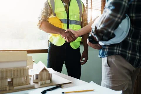 Engineers shaking hands to congratulate after success To create a building Stock Photos