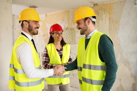 Engineers shaking hands at the construction site Stock Photos