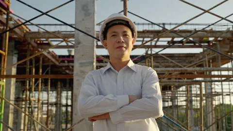 Engineers stand and cross one's arm inside the construction site. Stock Footage 169763807