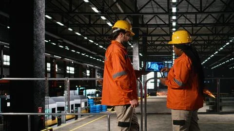 Engineers team analyzes AI brain interface inside heavy industry factory Stock Photos