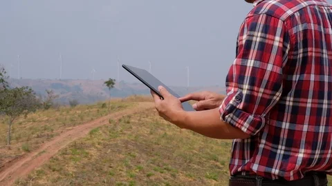Engineers use the tablet to inspect wind turbines Stock Footage 124778866